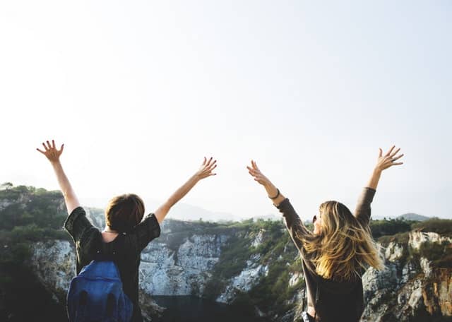 two students holding their arms in the air